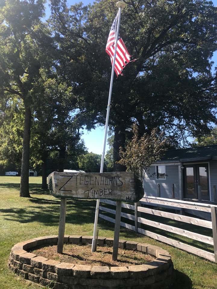 Ziegenhorn's Timber entrance sign with American flag and flagpole